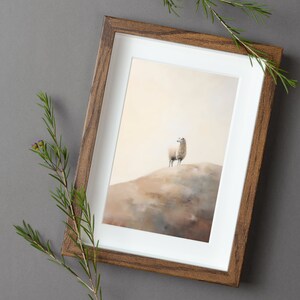 May include: A framed print of a white sheep standing on a hill. The sheep is looking up at the sky. The background is a soft, muted brown.
