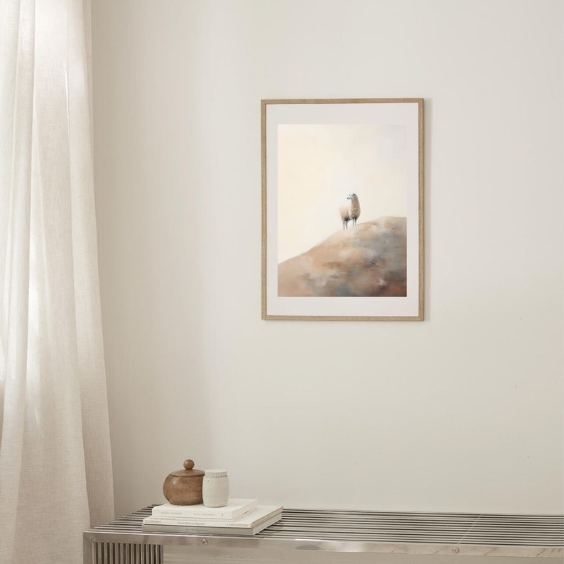 May include: A framed watercolour painting of a white sheep standing on a hilltop. The background is a soft, muted orange and blue.