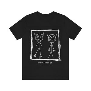 May include: Black t-shirt with a white graphic of two stick figures with horns and faces drawn in a square frame. The text "STARTAFIGHT" is below the frame.
