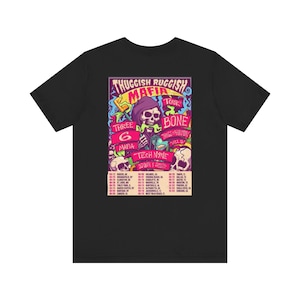 May include: Black t-shirt with a vibrant graphic. The design features the text "THUGGiSH RUGGiSH MAFIA TOUR" and a skull in a purple hood. It also includes the names "THREE 6 MAFIA", "BONE THUGS-N-HARMONY", and "TECH N9NE", with a list of tour dates.