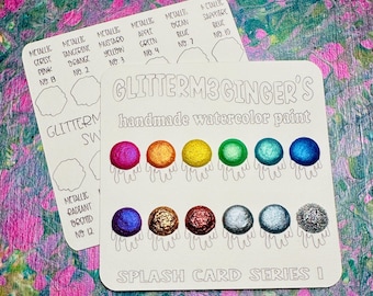 May include: A white card with the text "GlitterM3 Ginger's handmade watercolor paint" and "Splash Card Series I". The card shows 8 small circles of metallic watercolor paint in various colors, including pink, orange, yellow, green, blue, and silver.