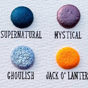 May include: A white card displays eight colorful paint swatches with names. Colors include green, blue, purple, and orange, labeled "Zombies," "Supernatural," "Mystical," "Peridot," "Amethyst," "Ghoulish," "Jack O' Lantern," and "Marigold."