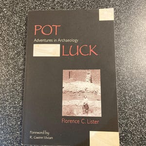 May include: A book titled "POT LUCK Adventures in Archaeology" by Florence C. Lister. The cover is black with red and white text. A sepia-toned photograph of an archaeological site is featured on the cover.