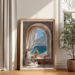 Puede incluir: Una impresión artística enmarcada representa una serena escena costera. Una ventana arqueada revela un mar y un cielo azules, con un jarrón blanco y conchas marinas en el alféizar. Suaves cortinas blancas enmarcan la vista, y la obra de arte está en un marco de madera clara.