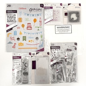 May include: A set of clear plastic sheets with various birthday-themed images and text, including "Celebrate", "Cheers", "Let's Party", and "Gemini by Crafter's Companion". The sheets are packaged in clear plastic bags with warning labels.