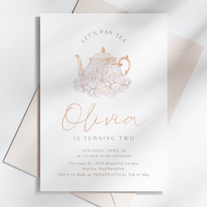 Peut inclure: Une invitation blanche avec une illustration de théière et de fleurs. Le texte indique "LET'S PAR-TEA" et "Olivia a deux ans". Comprend les détails de l'événement. Une enveloppe beige clair est derrière la carte. Design élégant pour une fête.
