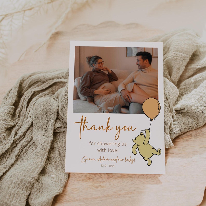 Pode incluir: Um cart&atilde;o de agradecimento com uma foto de uma mulher gr&aacute;vida e um homem. O cart&atilde;o apresenta um desenho animado do Winnie the Pooh segurando um bal&atilde;o e o texto "Obrigado por nos encher de amor! Grace, Adam e nosso beb&ecirc;! 22 01 2024".