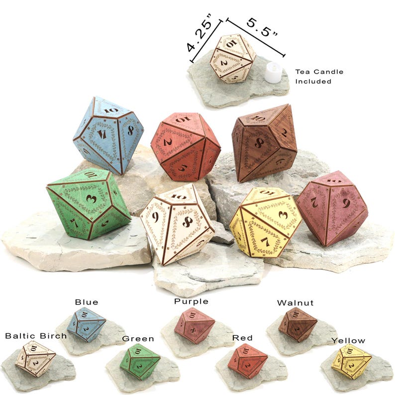 May include: A collection of multi-sided dice in various colors, including blue, green, red, and yellow. Each die features etched numbers and decorative leaf patterns. The largest die measures 5.5 inches across. A tea candle is included.