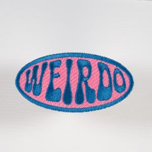 Weirdo Iron-on or Sew-on Machine Embroidered Patch with Blue Lettering on Pink Background