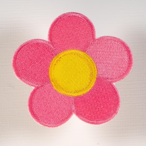 May include: A flower-shaped embroidered patch featuring five rounded pink petals surrounding a solid yellow circular center. The design is stitched with a dense thread texture and finished with a clean, stitched border around the entire shape.