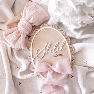 Plaque à nom personnalisée avec bordure festonnée pour bébé fille avec ruban
