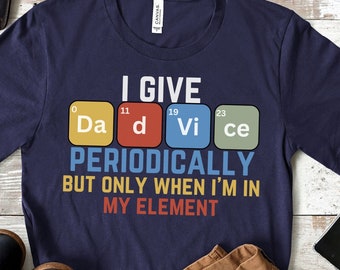 May include: A navy blue t-shirt with a white graphic print that says "I give Dadvice periodically but only when I'm in my element". The graphic is made up of four colorful squares with the chemical symbols for the elements Da, D, Vi, and Ce.