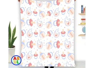 May include: White baby blanket with a repeating pattern of blue baby bottles, pink pacifiers, and light blue bibs with pink hearts. The background is white with small white stars.