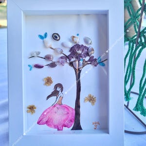 May include: A framed artwork featuring a tree made of seashells and a girl with pink flower petals for a dress. The artwork is signed "with love".