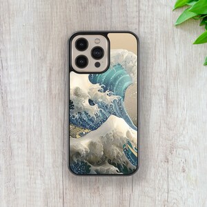 May include: A black phone case with a graphic of a large blue wave crashing against a mountain. The wave is depicted in a traditional Japanese style.