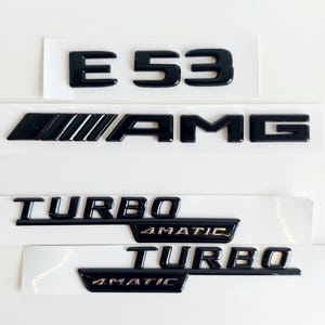 Puede incluir: Emblemas de coche de plástico negro con el texto "E 53 AMG TURBO 4MATIC" en acabado brillante.