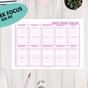 Può includere: Un planner stampabile di due settimane con bordi rosa e un titolo che recita "Two Week Focus". Il planner è diviso in due settimane, con ogni settimana che ha una colonna per ogni giorno della settimana: lunedì, martedì, mercoledì, giovedì e venerdì. Ogni giorno ha una sezione per "Mattina", "Pomeriggio" e "Prossimo".