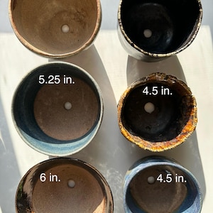May include: Six ceramic plant pots in various sizes and colors. The pots are 4, 4.5, 5, 5.25, and 6 inches in diameter.