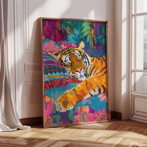 K&ouml;nnte beinhalten: Ein lebendiger Kunstdruck mit einem ruhenden Tiger. Das Kunstwerk zeigt den Tiger in Orange- und Schwarzt&ouml;nen vor einem farbenfrohen Hintergrund aus tropischem Laub und Blumen. Der Rahmen ist goldfarben.