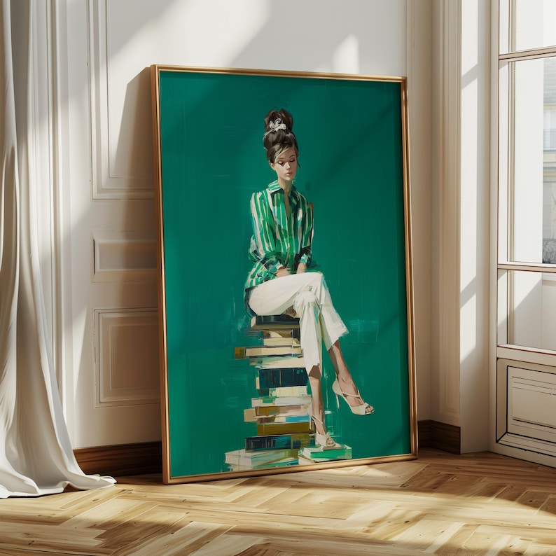 May include: A framed art print featuring a woman in a green and white striped shirt and white pants, seated atop a stack of books. The artwork has a gold frame and a vibrant green background. The woman wears high heels.