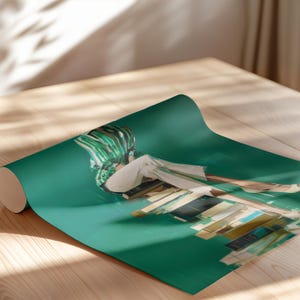 May include: A rolled-up yoga mat with a teal green background. The mat features an abstract art print with a person wearing white clothing and a green and white striped head covering. The mat is on a wooden surface.