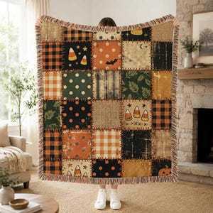 May include: A rectangular woven throw blanket featuring a patchwork design of various Halloween-themed patterns including orange and black buffalo plaid, polka dots, candy corn, bats, pumpkins, and textured burlap-style squares with fringed edges.