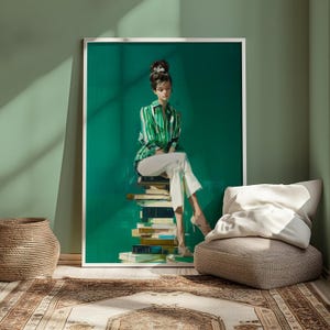 May include: A framed art print depicts a person in a green and white striped shirt and white pants, seated atop a stack of books. The artwork is set against a vibrant green backdrop, with a white frame. The room features a woven basket, a patterned rug, and a neutral-toned seat.