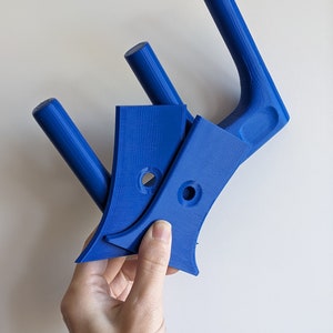 May include: Three blue plastic wall mounted hooks. The hooks are designed to hold items like coats, hats, or bags.