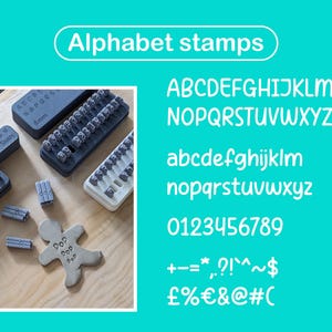 Può includere: Timbri alfabetici grigi di varie dimensioni e caratteri sono esposti su una superficie di legno. L'immagine mostra diversi set di timbri con lettere e numeri, insieme a un omino di pan di zenzero timbrato con la parola "Pop". Il testo "Alphabet stamps" è in alto.