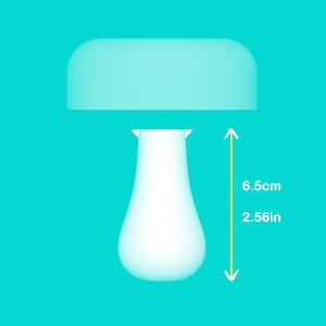 Peut inclure: Une lampe blanche en forme de champignon avec un dessus arrondi et une base en forme de goutte d'eau. La lampe mesure 6,5 cm (2,56 pouces) de haut. Le fond est de couleur turquoise uni.
