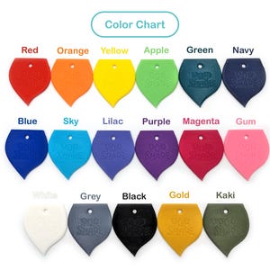 Puede incluir: Carta de colores que muestra 15 colores diferentes de dijes de silicona en forma de hoja. Los colores son rojo, naranja, amarillo, verde manzana, verde, azul marino, azul, azul cielo, lila, morado, magenta, chicle, blanco, gris, negro, dorado y kaki.