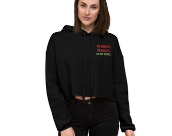 Op de afbeelding: Zwarte cropped hoodie met een motiverende quote: "You should've. You could've. And now you will."
