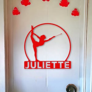 Peut inclure: Silhouette rouge d'une figure tenant un bâton, avec un cercle autour de la figure et le nom "JULIETTE" en dessous.