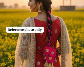 May include: A woman in a red suit with floral sleeves and a sheer scarf. Her dark hair is braided with pink highlights and a decorative tassel. The background is a field of yellow flowers, with a sunset.
