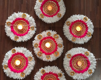 May include: Seven white paper diya decorations with pink and gold accents. Each diya has a small candle in the center.