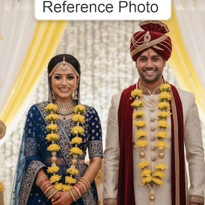 May include: A couple in traditional Indian wedding attire. The woman wears a blue embroidered outfit with floral garlands and jewelry. The man wears a cream-colored suit, a red scarf, and a turban, also adorned with garlands. The text "Reference Photo" is in a white box.