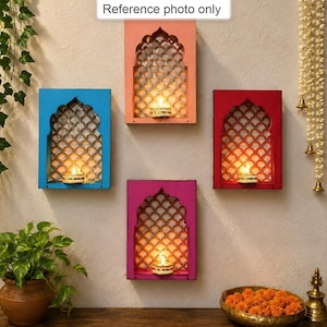 May include: Four rectangular wall-mounted candle holders in blue, peach, red, and magenta, each featuring an arched cutout with a scalloped lattice pattern and a small lit tea light candle. A sign above the top holder reads Reference photo only.