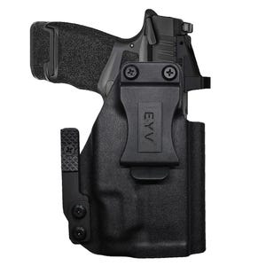 May include: Black handgun in a black holster. The holster has a belt clip with the letters "EYV" printed on it. The handgun has a textured grip and a sight on top.