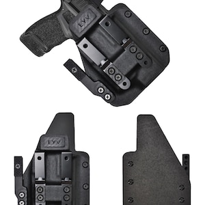 May include: Black polymer holster with a handgun. The holster has a textured surface and features metal clips and screws. The handgun is black with a textured grip and a red dot sight. The text "EYV" is visible on the holster.