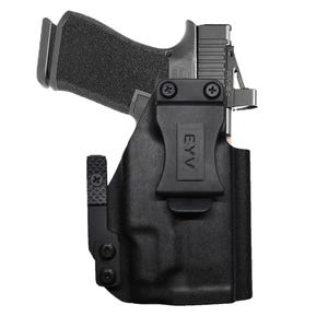 May include: Black handgun in a black holster. The holster has a belt clip and the text "EYV" is visible. The handgun is partially visible, showing the grip and slide. The background is white.