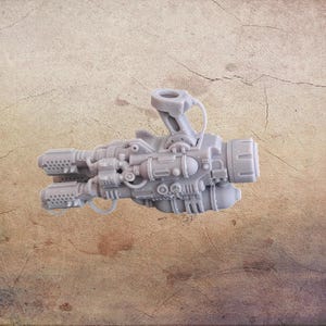 Könnte beinhalten: Eine graue, detaillierte Miniatur-Sci-Fi-Waffe mit mehreren Läufen, Rohren und einem oben angebrachten Griff. Das Modell hat ein komplexes, mechanisches Design, das auf ein futuristisches oder industrielles Thema hindeutet. Die Waffe besteht aus einem festen, möglicherweise Kunststoffmaterial.