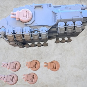 May include: A gray plastic model of a tank with a brown plastic turret and six brown plastic feet. The tank has a detailed design with many small parts.