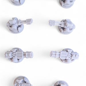 Peut inclure: Six vues différentes d'une tourelle miniature en plastique gris avec un canon. La tourelle est conçue pour être utilisée dans un jeu de guerre sur table.