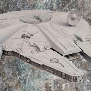 Op de afbeelding: Een lichtgrijs, ongelakt plastic model van een ruimteschip met een cirkelvormige romp, een opvallende sensorschotel aan de bovenzijde en twee naar voren uitstekende kaken. Het oppervlak vertoont gedetailleerde mechanische structuren.