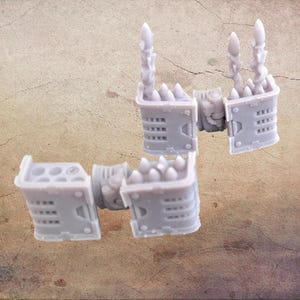 Op de afbeelding: Verschillende lichtgrijze miniatuurmodelcomponenten, mogelijk voor een tabletopspel of hobbyproject. De stukken hebben een mechanische of futuristische esthetiek, met gedetailleerde texturen en vormen, waaronder spikes en cilindrische elementen.