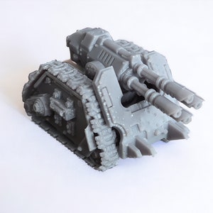 Puede incluir: Un modelo de tanque de plástico gris con un cañón grande en la parte superior. El tanque tiene orugas y un diseño detallado.