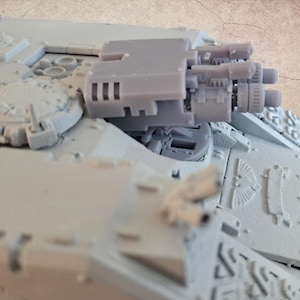 Op de afbeelding: Een lichtgrijs miniatuur tankmodel met gedetailleerde kenmerken, waaronder een multi-loop geschutskoepel en ingewikkelde oppervlakte details. Het model is ontworpen voor hobbyisten en verzamelaars.