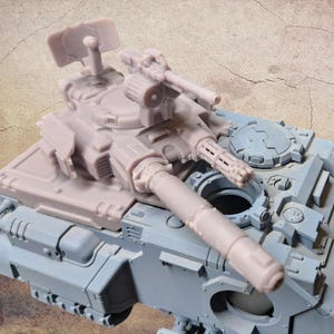 May include: A light grey and pale pink plastic model tank featuring a large main cannon, a secondary multi-barrelled weapon, and a radar dish mounted on the turret. The vehicle has a detailed armoured hull with various hatches, vents, and panels.