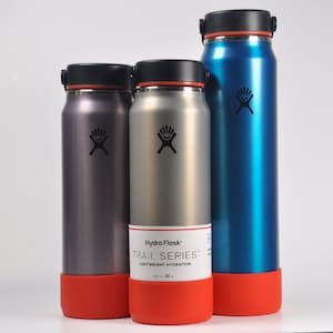 May include: Three stainless steel water bottles with different colored powder coats. The bottles are all Hydro Flask brand and have the Hydro Flask logo on them. The bottles are all labeled "Trail Series" and "Lightweight Hydration". The bottles are 32 ounces.