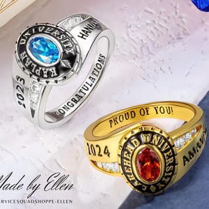 May include: Two graduation rings with blue and red gemstones. The silver ring has the words "Laplan University" and "Congratulations" engraved on it. The gold ring has the words "Ashehead University" and "Proud of You!" engraved on it.